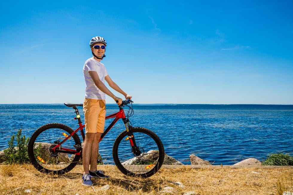 young man biking at seaside