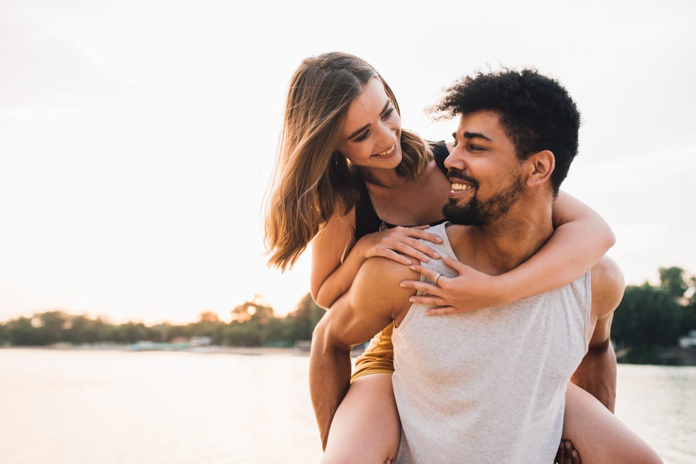 young man carrying woman piggyback style