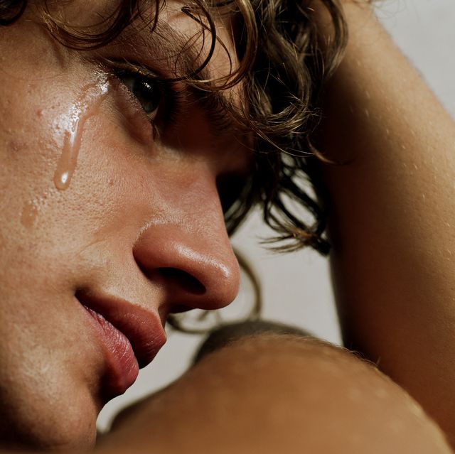 young man crying, head in hand, close up