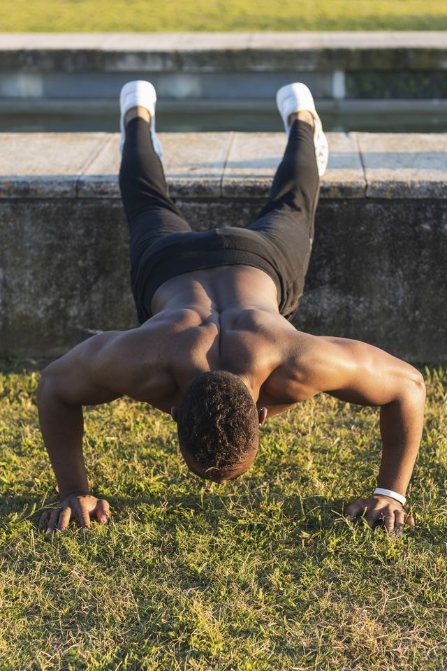 young man doing push ups while exercising at park