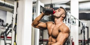 young man drinking his proteins at the gym