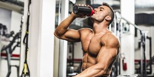 young man drinking his proteins at the gym