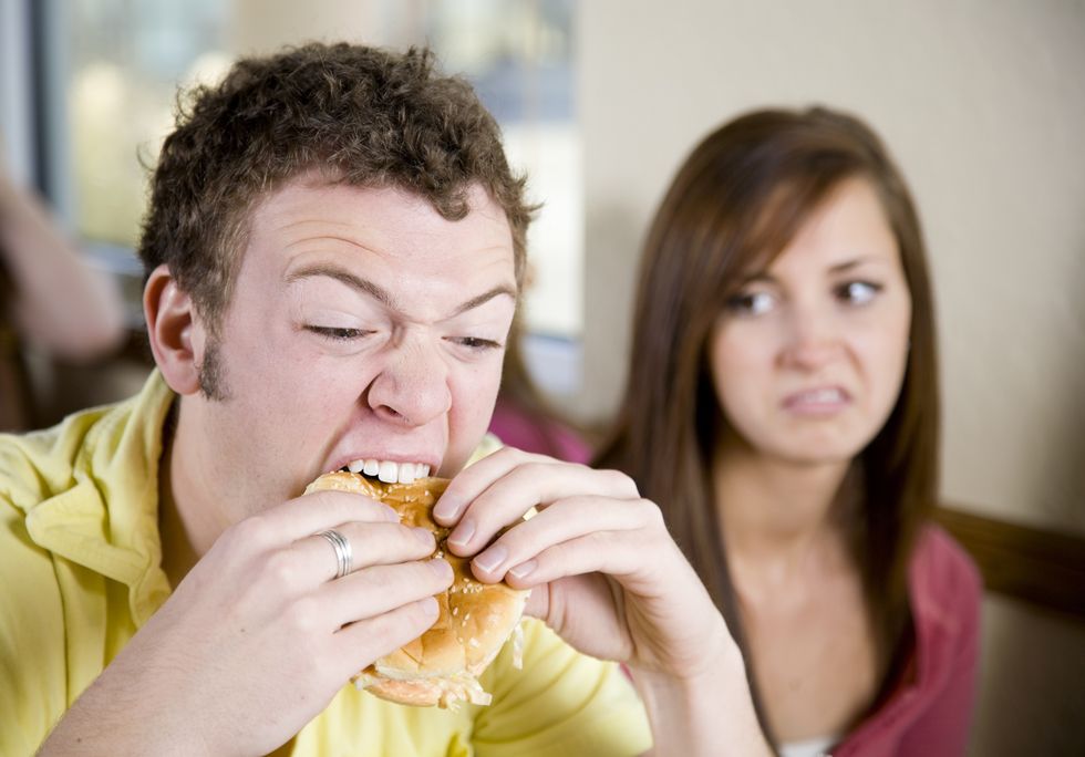 young man eating a cheeseburger