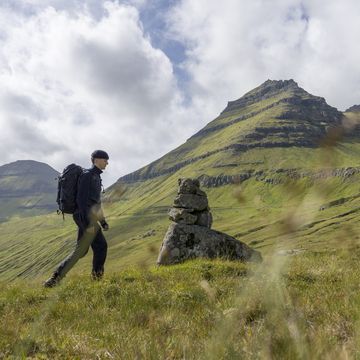 young man explores lush meadows in remote landscape