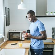young man having breakfast in kitchen at home