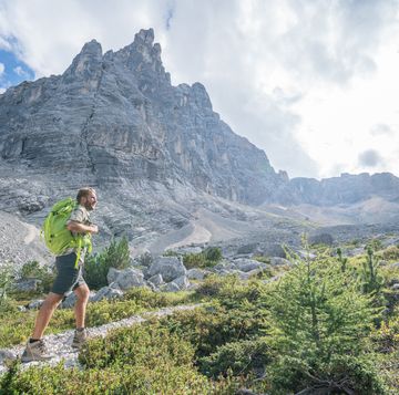 young man hiking in the dolomites, alto adige, italy