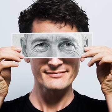 Young man holding picture of old eyes over his young man holding picture of old eyes over his