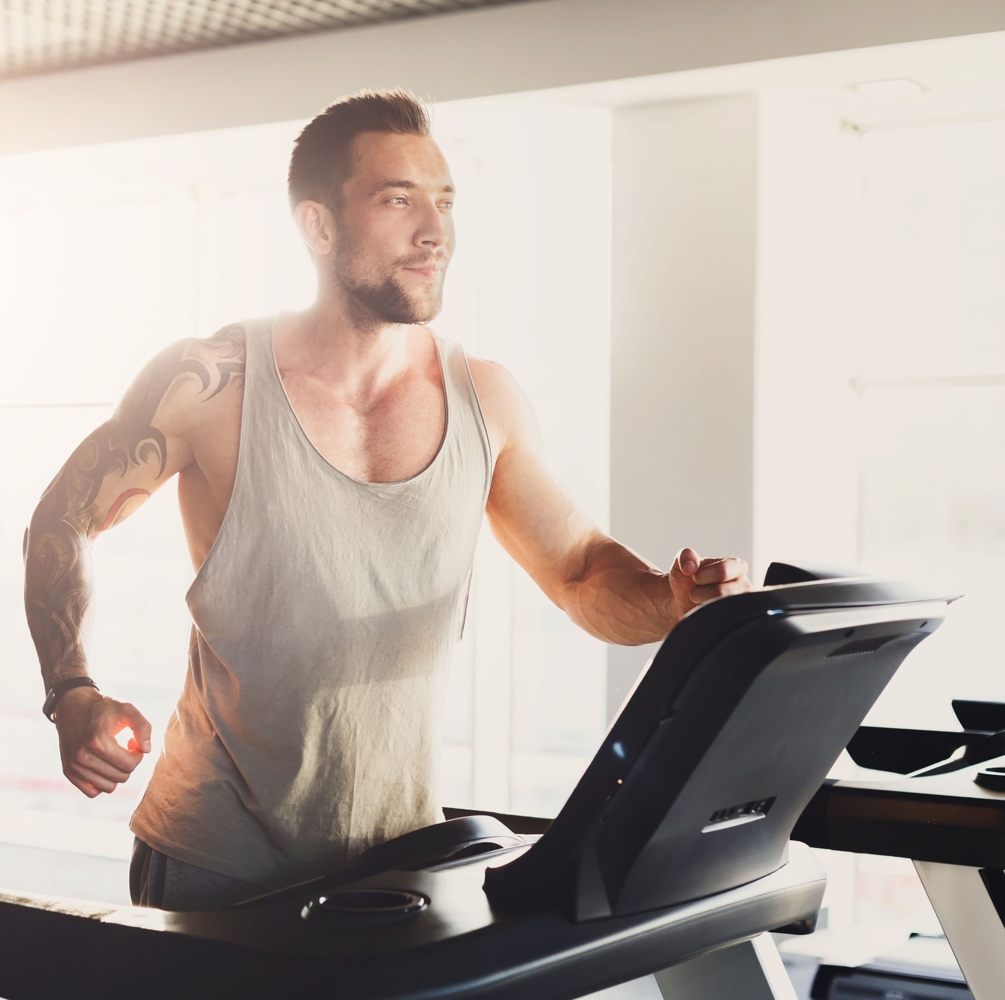 young man in gym run on treadmill