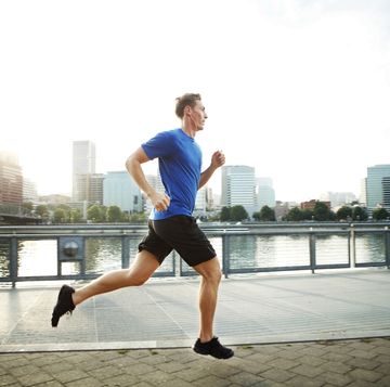young man jogging on promenade in city