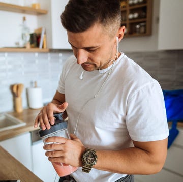 young man making protein shake before training