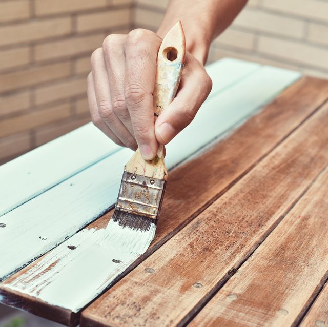 young man painting an old wooden table