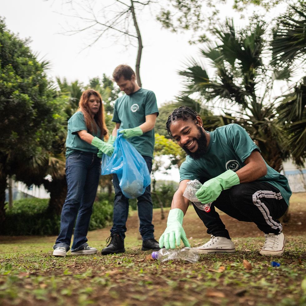 young man picking up garbage to clean a public park