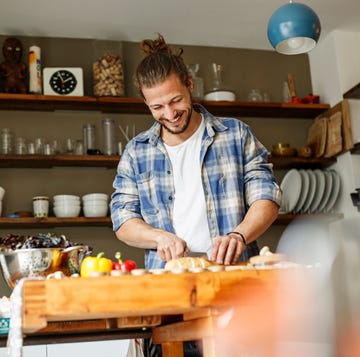 man snijdt eten in de keuken