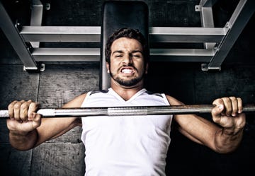 young man putting effort in on a bench press