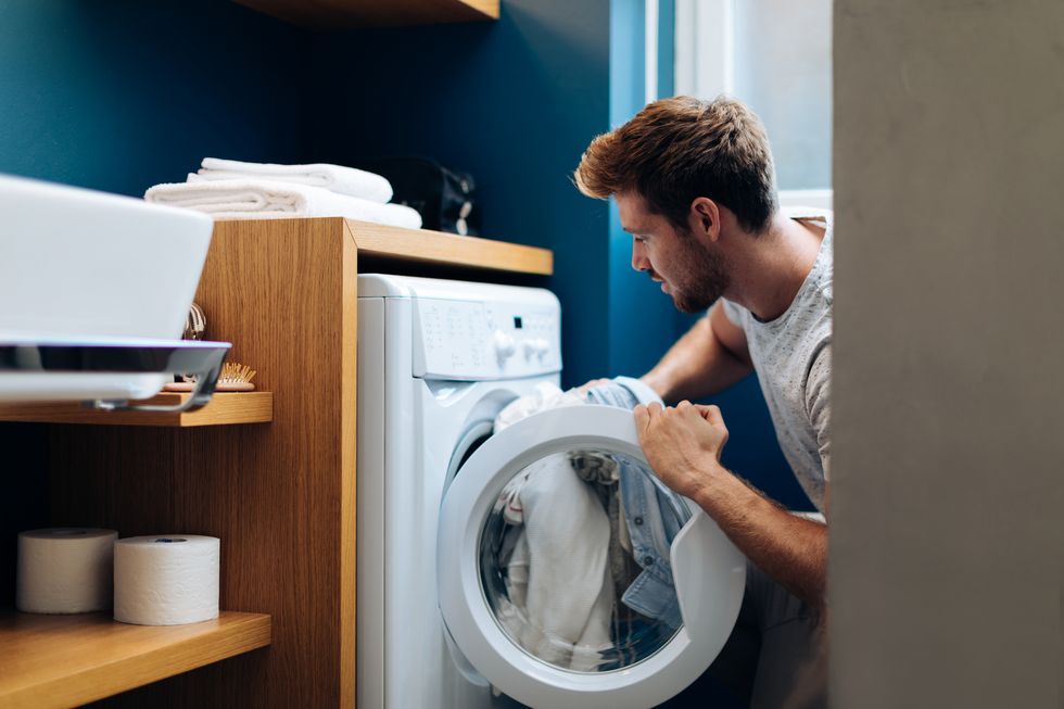 洗濯機から洗濯物を取り出す男性