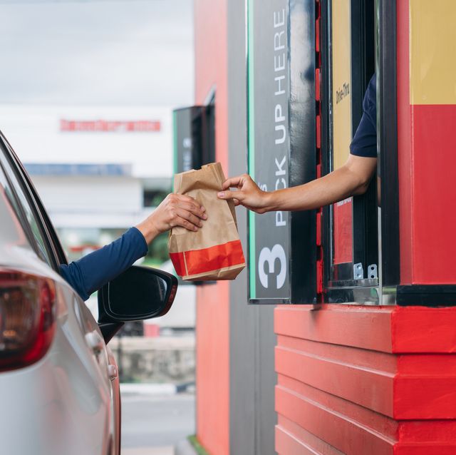 young man receiving coffee at drive thru counter, drive thru and take away for protect covid19