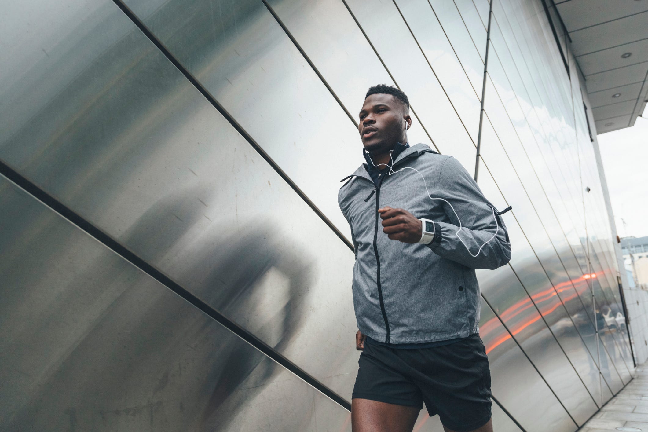young man running along building front
