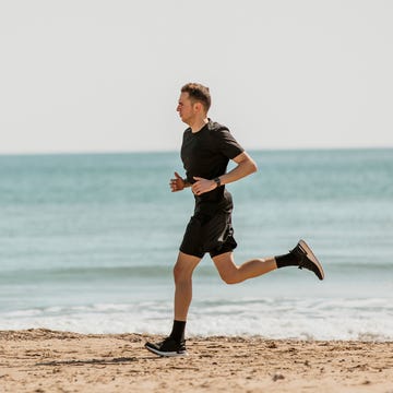 Young man running at beach during sunny day young man running at beach during sunny day