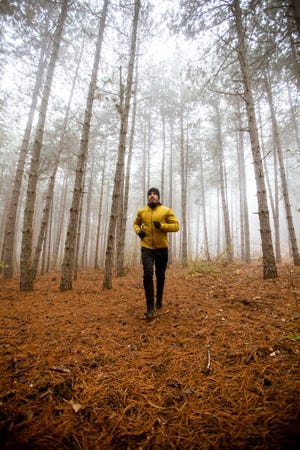 young man running in autumn forest and exercising for trail run marathon endurance race