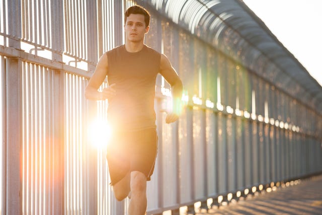 young man running on bike path in urban city setting