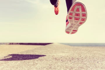 Young man running outdoors, mid air, low section