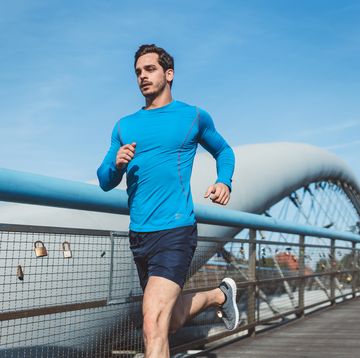 young man running over a bridge