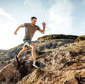 young man runs on mountain ridge