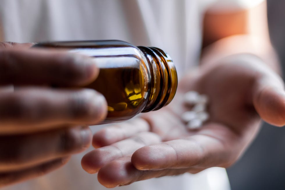 young man spilling multiple pills in his hand