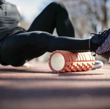 young man stretching himself on a foam roller