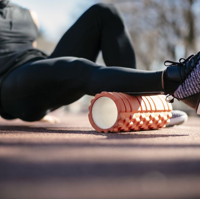 young man stretching himself on a foam roller