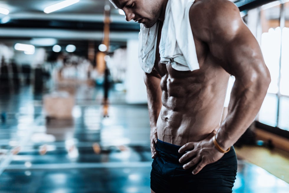 young man tired after training showing his abdominal muscles