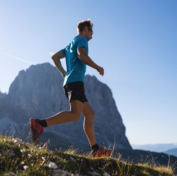 young man trail running on the dolomites mountain