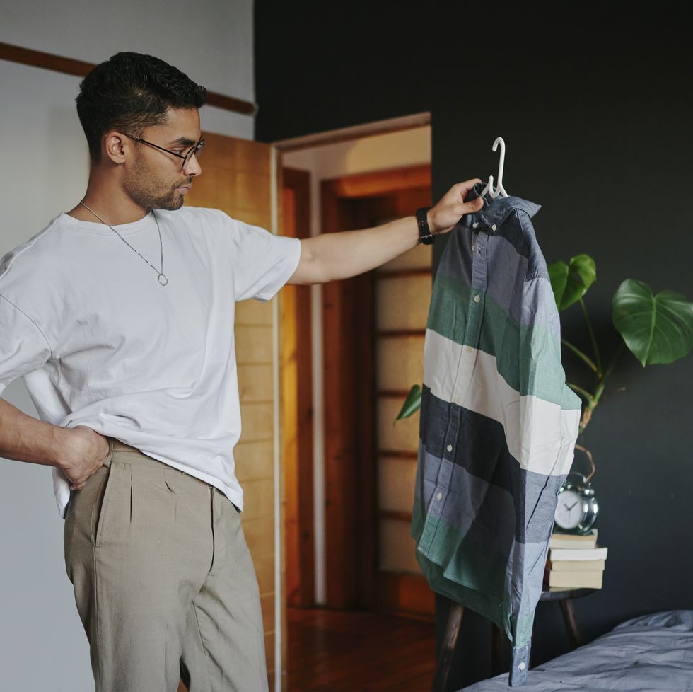 young man trying to choose an outfit before a date