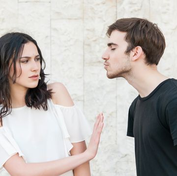 young man trying to kiss a young woman