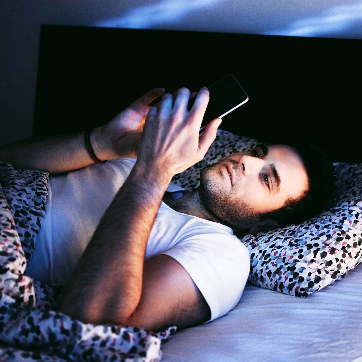 man on phone in bed
