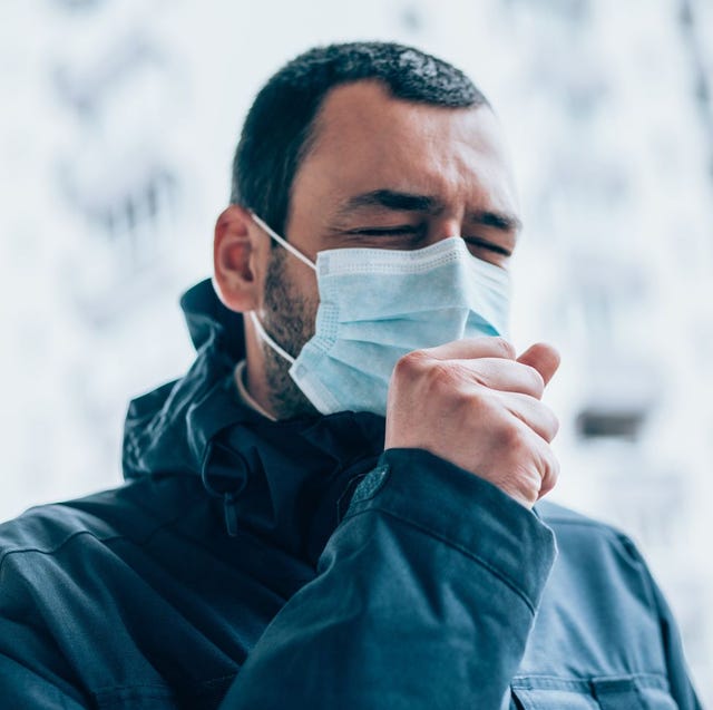 young man wear face mask and coughing outdoors
