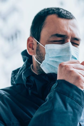 Young man wear face mask and coughing outdoors. young man wear face mask and coughing outdoors