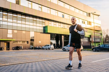 young man with a backpack walking home after a workout