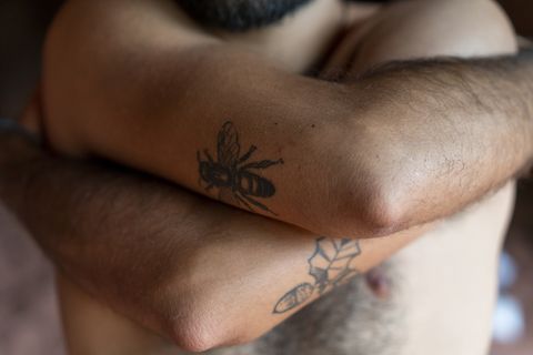 young man with tattoos on his upper arms