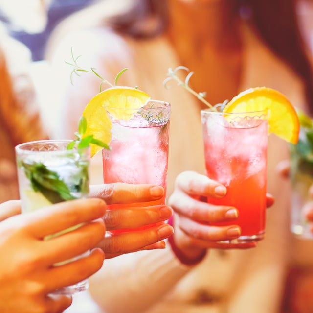 young men and women drinking cocktail at party