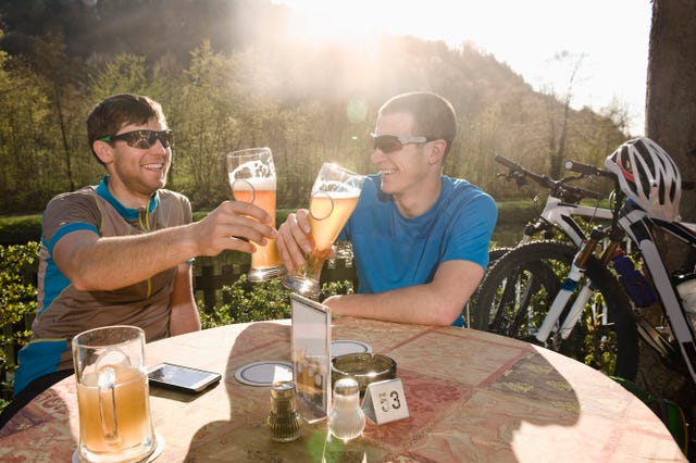 dos jóvenes ciclistas bebiendo cerveza