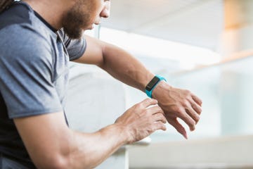 Young mixed race man checking his fitness tracker