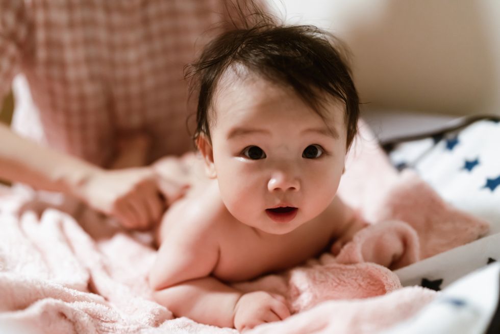 bebé niña asiática a la que están limpiando