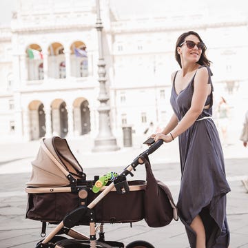 young mother walking a city with her baby in trieste, italy
