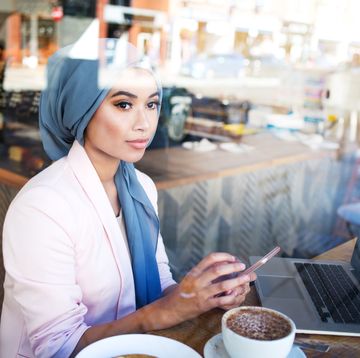 young muslim woman working in cafe