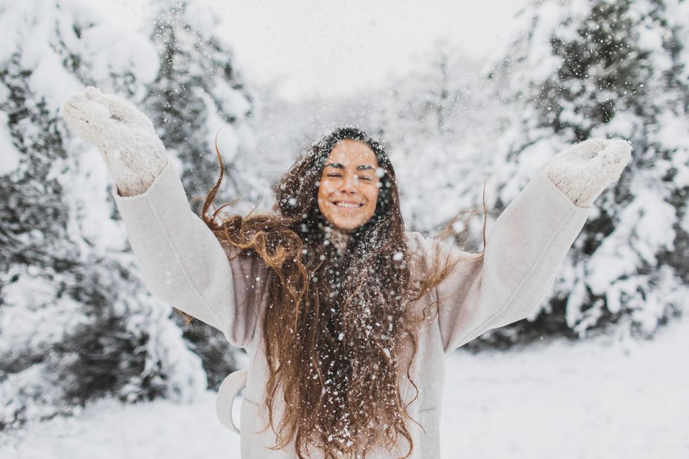 young pretty happy girl enjoying winter and beautiful snowy nature portrait close up