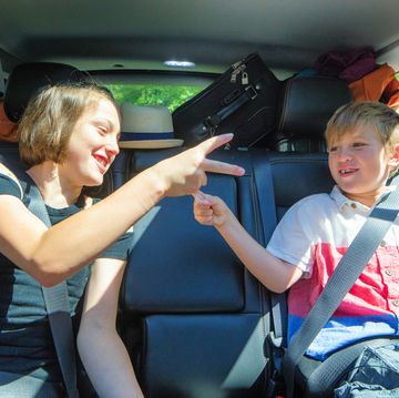 young siblings playing in packed car on a road trip