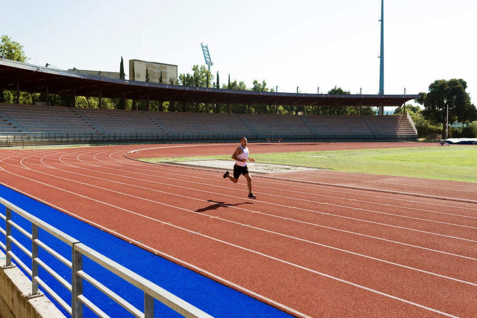 young sportsman running on tartan track