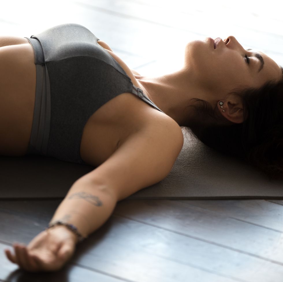 young sporty attractive woman practicing yoga, dead body pose