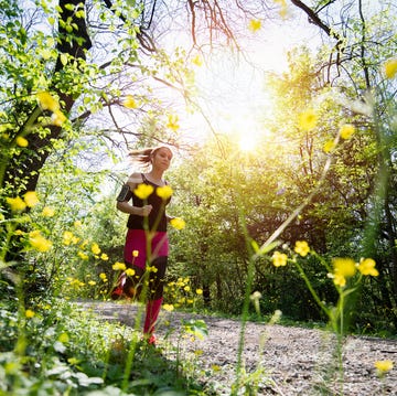 young sporty woman jogging through the forest